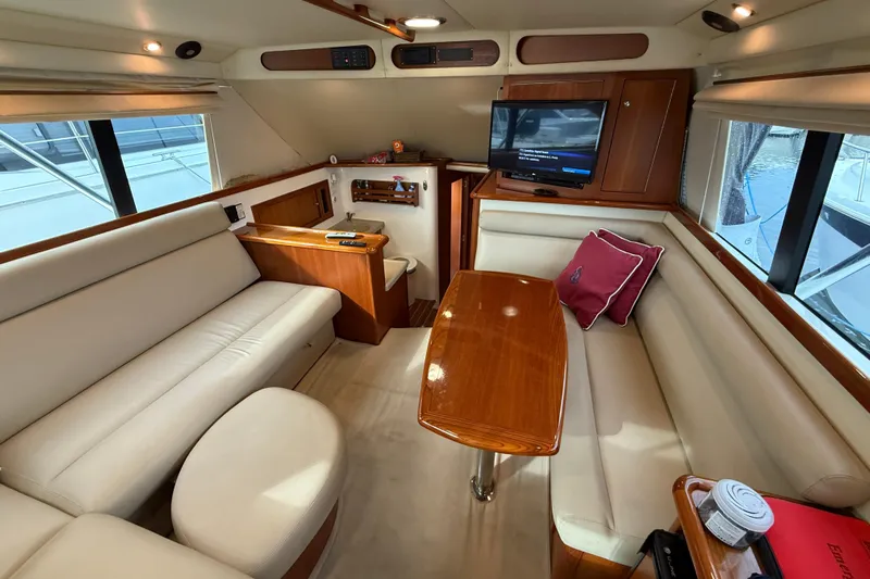  Yacht Photos Pics Luxurious interior of 2005 Riviera 40 Flybridge yacht with elegant seating and wooden table.