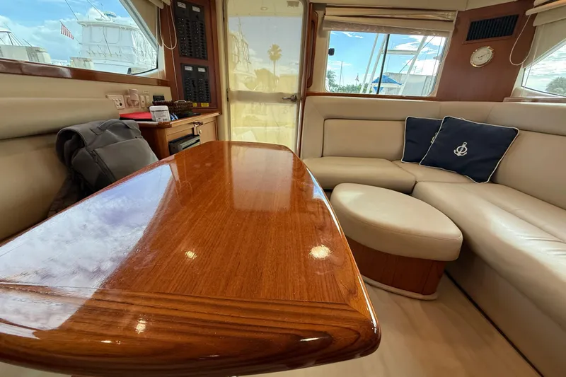  Yacht Photos Pics Luxurious interior of 2005 Riviera 40 Flybridge yacht with polished wood table and plush seating.