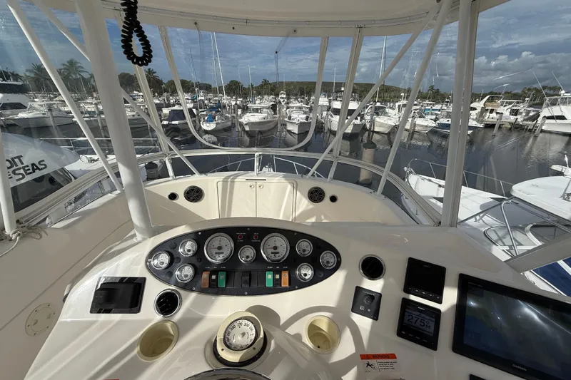  Yacht Photos Pics Cockpit view of 2005 Riviera 40 Flybridge yacht at marina, showcasing control panel and gauges.