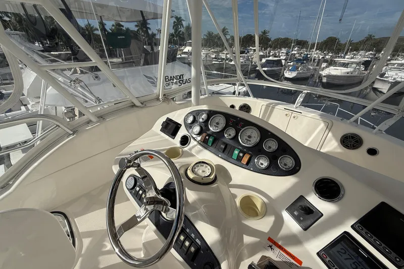  Yacht Photos Pics Helm of 2005 Riviera 40 Flybridge yacht with gauges and steering wheel, docked at marina.