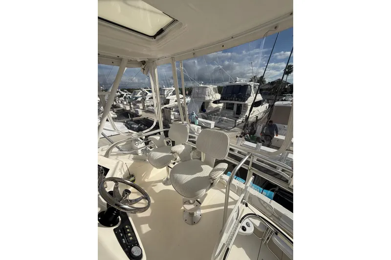  Yacht Photos Pics Flybridge view of 2005 Riviera 40 yacht, showcasing helm and marina backdrop.