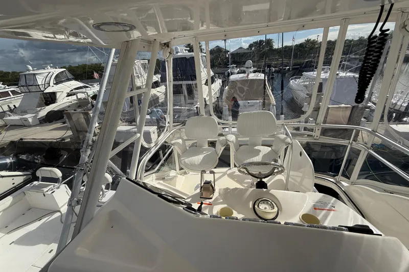  Yacht Photos Pics 2005 Riviera 40 Flybridge yacht interior with helm, docked among other boats.