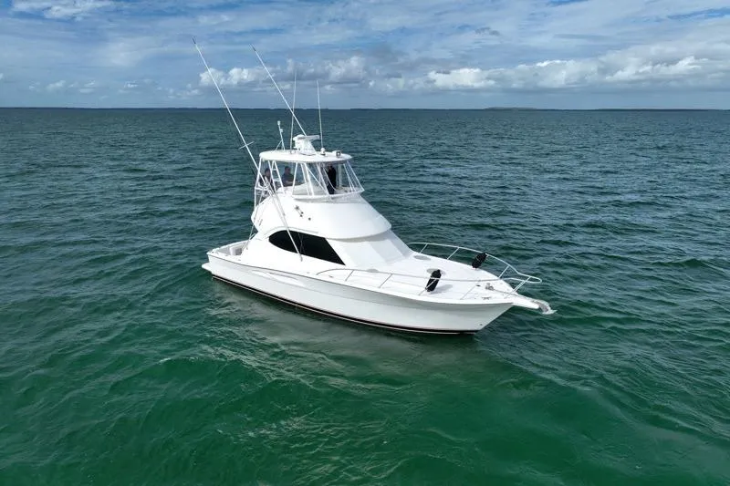  Yacht Photos Pics 2005 Riviera 40 Flybridge yacht cruising on open sea under blue sky.