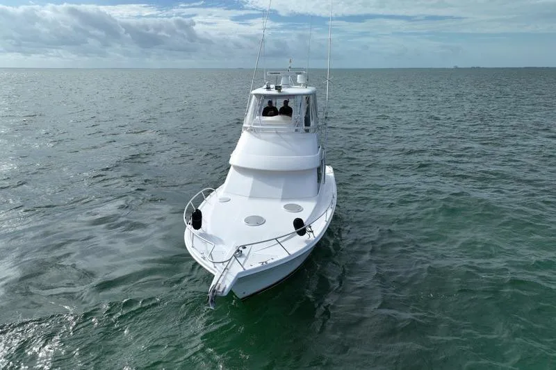  Yacht Photos Pics 2005 Riviera 40 Flybridge yacht cruising on open sea under cloudy sky.