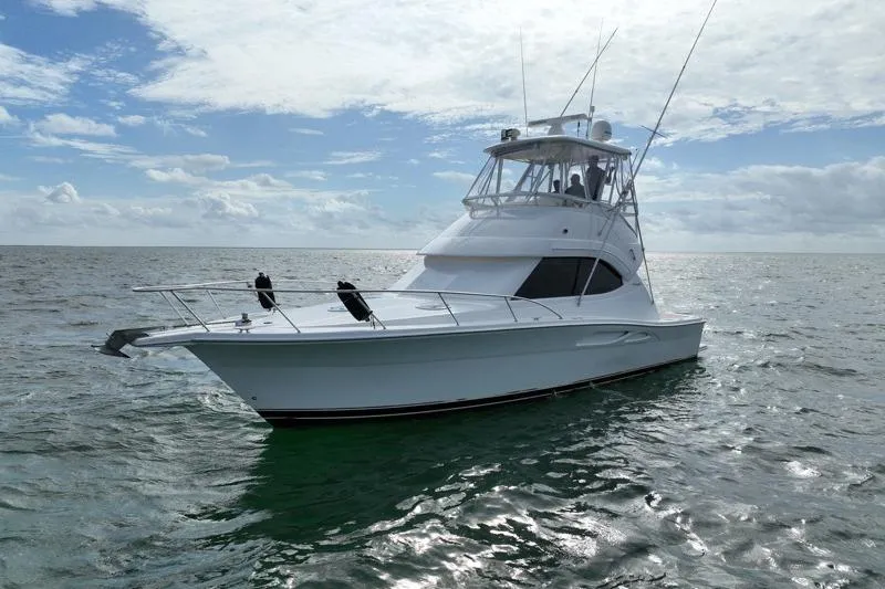  Yacht Photos Pics 2005 Riviera 40 Flybridge yacht on open water under a partly cloudy sky.