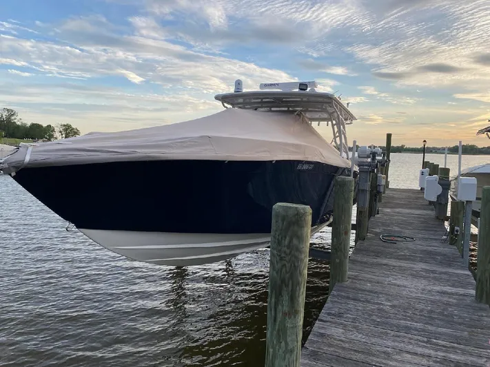  Yacht Photos Pics 2019 Midnight Express 39 Cuddy boat docked, covered, under a cloudy sky.
