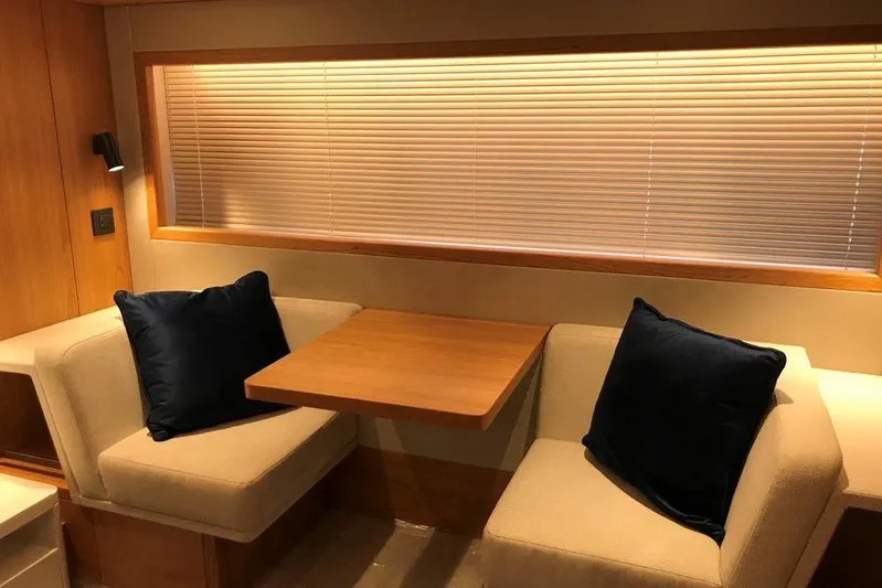 Alexstar Yacht Photos Pics Interior of 2021 Sunseeker Manhattan 68 yacht with cozy seating and wooden table.
