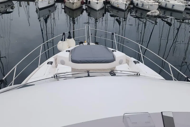 Alexstar Yacht Photos Pics 2021 Sunseeker Manhattan 68 yacht bow view in marina, surrounded by boats.