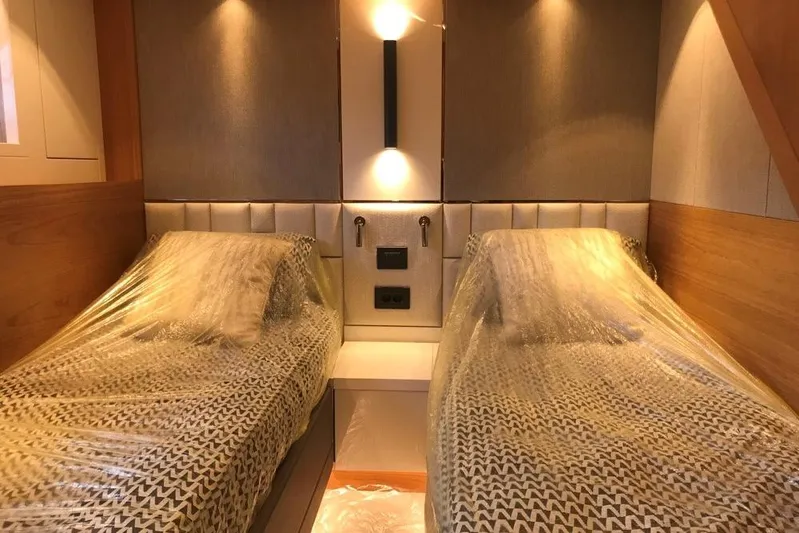 Alexstar Yacht Photos Pics Luxurious twin cabin interior of 2021 Sunseeker Manhattan 68 yacht, featuring modern lighting.