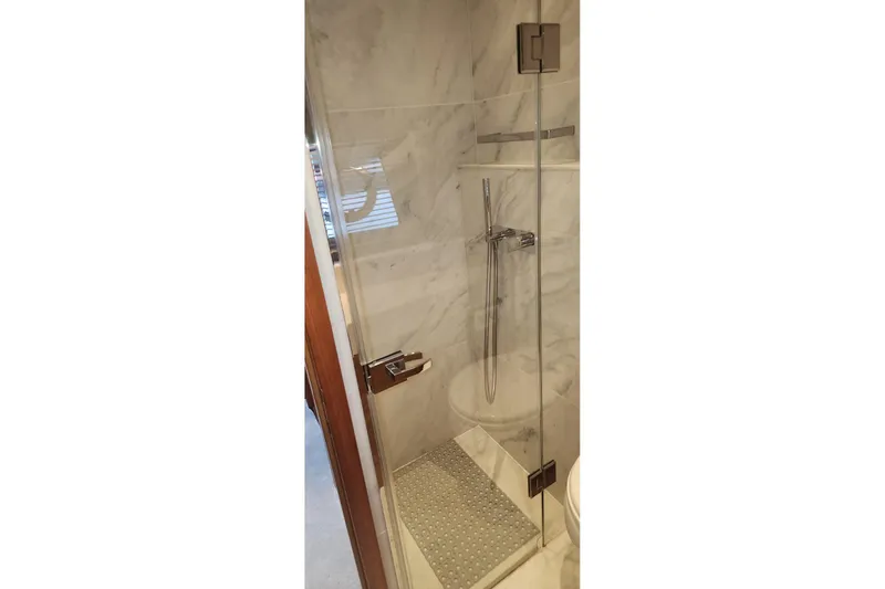 Alexstar Yacht Photos Pics Luxurious shower area in 2021 Sunseeker Manhattan 68 yacht, featuring elegant marble design.