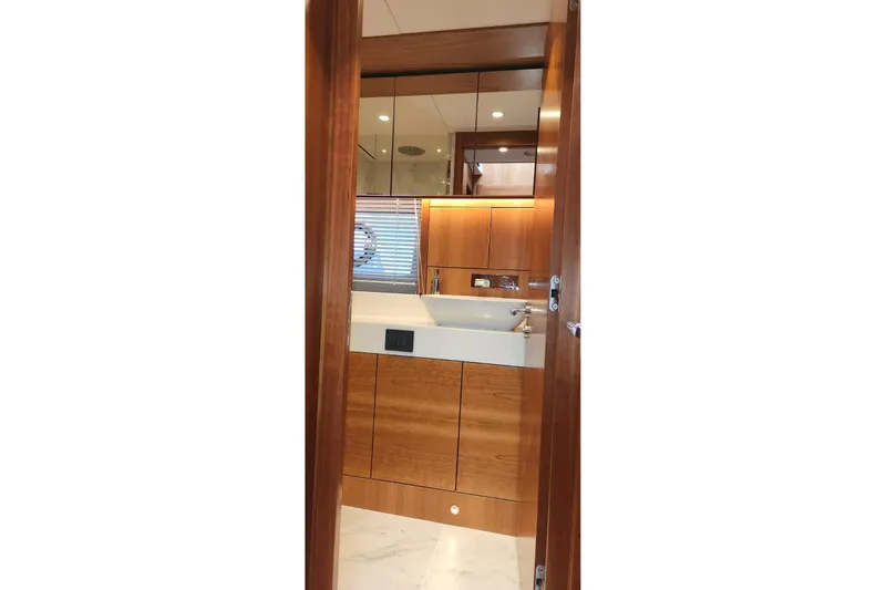 Alexstar Yacht Photos Pics Luxurious bathroom interior of 2021 Sunseeker Manhattan 68 yacht with wooden cabinetry.