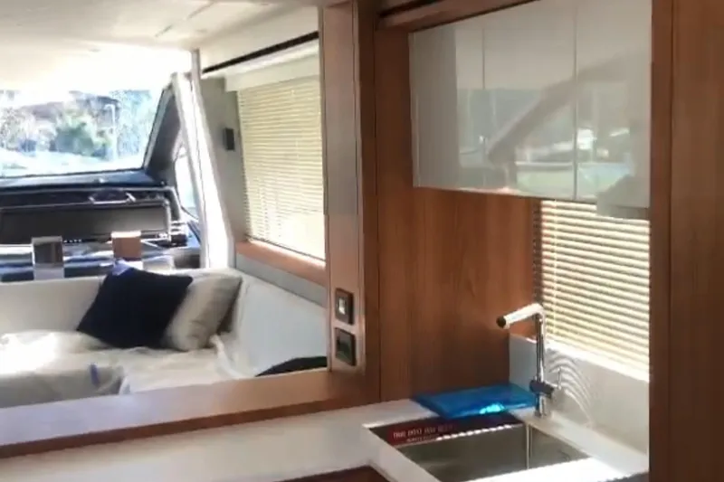 Alexstar Yacht Photos Pics Luxurious interior of 2021 Sunseeker Manhattan 68 yacht, featuring modern kitchen and cozy seating area.