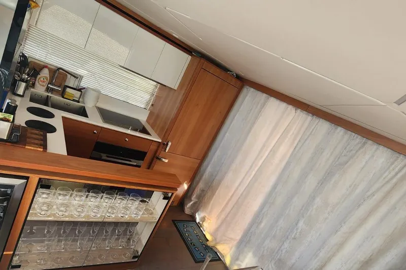 Alexstar Yacht Photos Pics Modern kitchen interior on 2021 Sunseeker Manhattan 68 yacht, featuring sleek cabinetry and glassware.