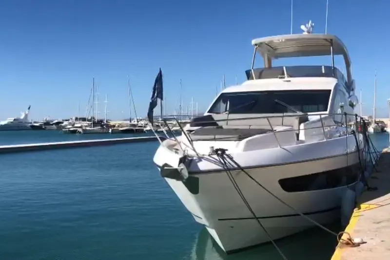 Alexstar Yacht Photos Pics 2021 Sunseeker Manhattan 68 yacht docked in a marina under clear blue skies.