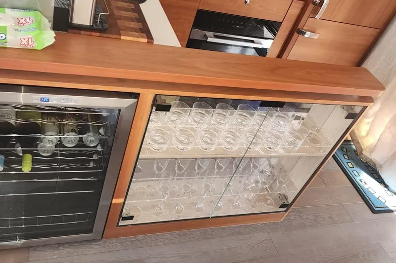 Alexstar Yacht Photos Pics Kitchen area on a 2021 Sunseeker Manhattan 68 yacht with wine fridge and glass cabinet.