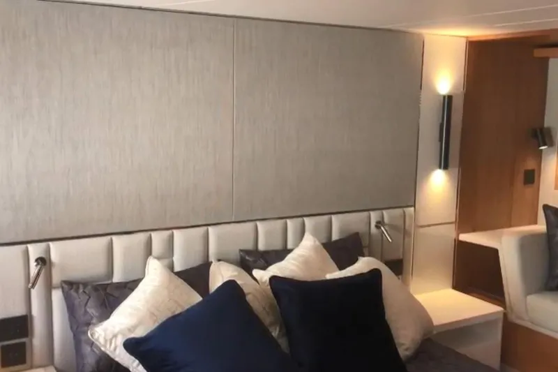 Alexstar Yacht Photos Pics Luxurious bedroom interior of 2021 Sunseeker Manhattan 68 yacht with elegant lighting and cushions.
