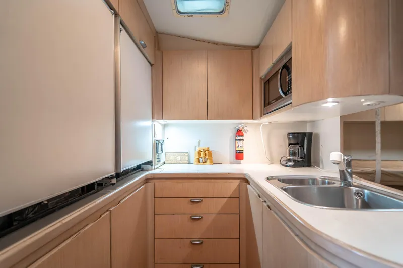 Amadeus Yacht Photos Pics 1995 Tiara Yachts 4300 Open kitchen with modern appliances and wooden cabinetry.