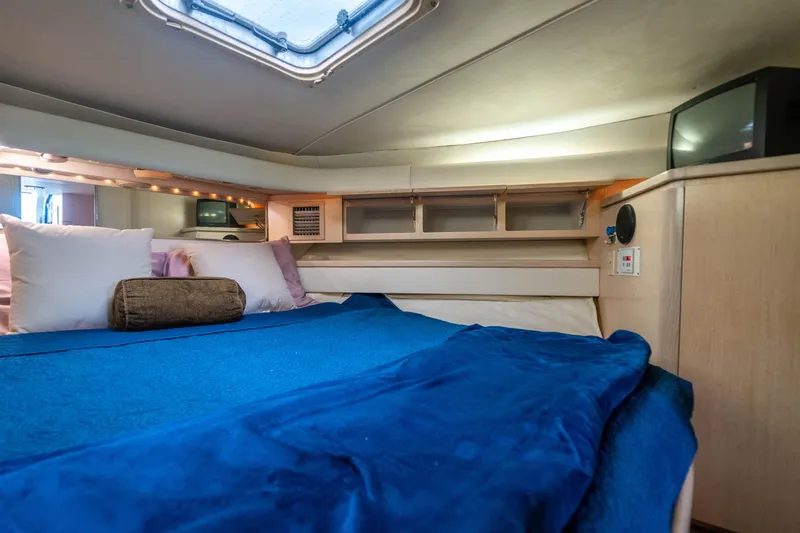 Amadeus Yacht Photos Pics Cozy cabin interior of 1995 Tiara Yachts 4300 Open with blue bedding and storage.