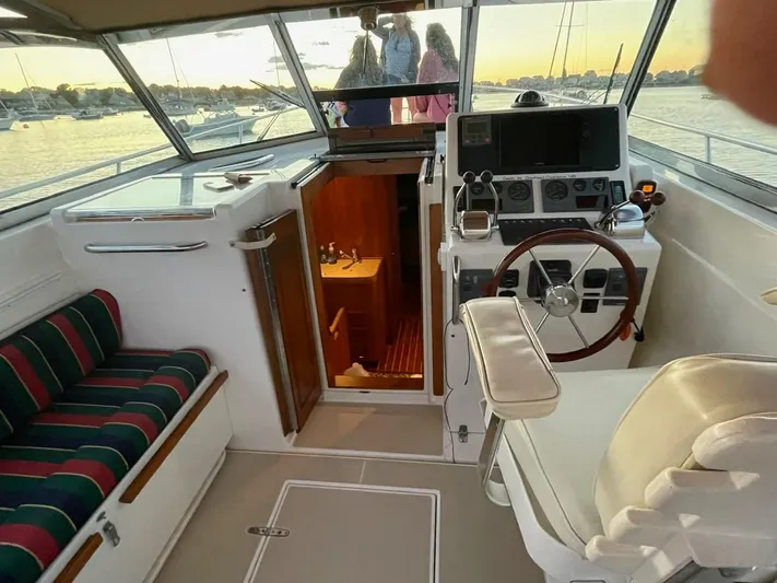 Off-line Yacht Photos Pics Interior of 2002 Sabre 36 boat with helm, seating, and cabin entrance.
