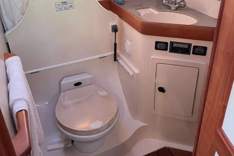 Off-line Yacht Photos Pics 2002 Sabre 36 yacht bathroom with toilet, sink, and wooden accents.