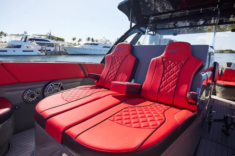  Yacht Photos Pics Luxurious red seating on 2023 Midnight Express 37' Open boat, docked with yachts in background.
