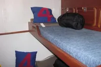 Bunk bed with blue bedding and numbered pillows on Devonport Challenge 67 yacht, 1995.