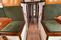 Interior of 1995 Devonport Challenge 67 yacht with wooden flooring and green cushioned seating.