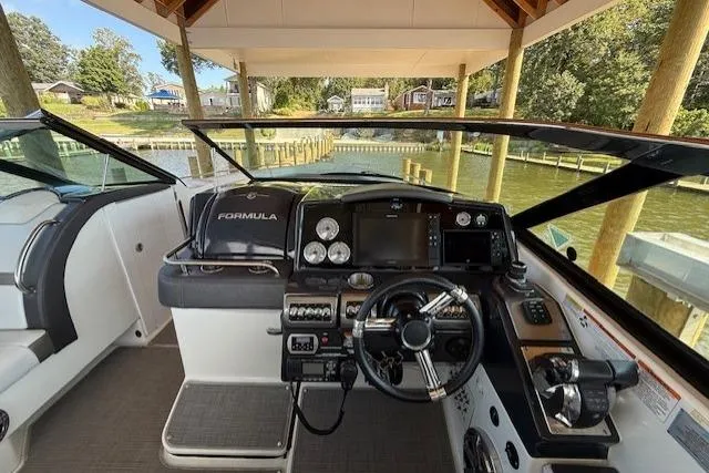  Yacht Photos Pics 2018 Formula 350 Crossover Bowrider OB cockpit with modern controls and scenic waterfront view.