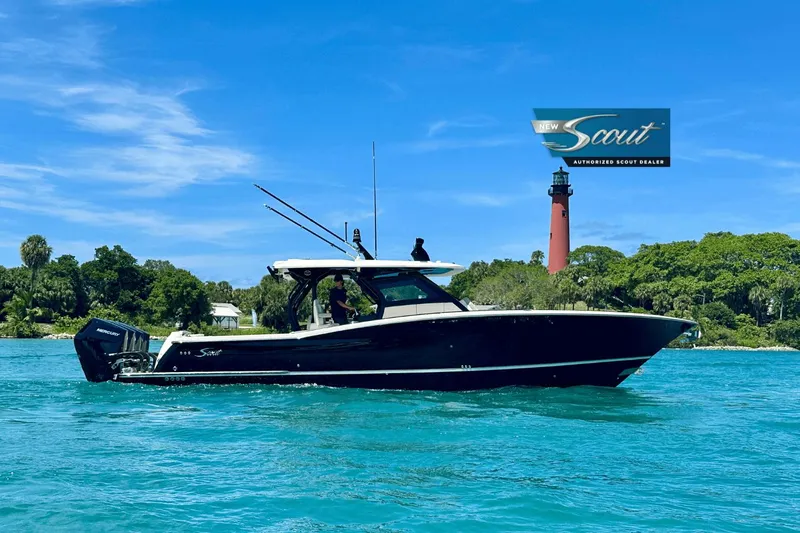  Yacht Photos Pics 2025 Scout 400 LXF boat cruising on clear blue water near a lighthouse.