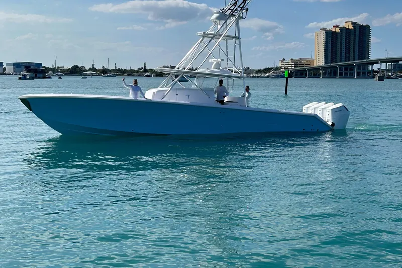  Yacht Photos Pics 2023 Sparks 46 boat cruising on clear blue water near a city skyline.