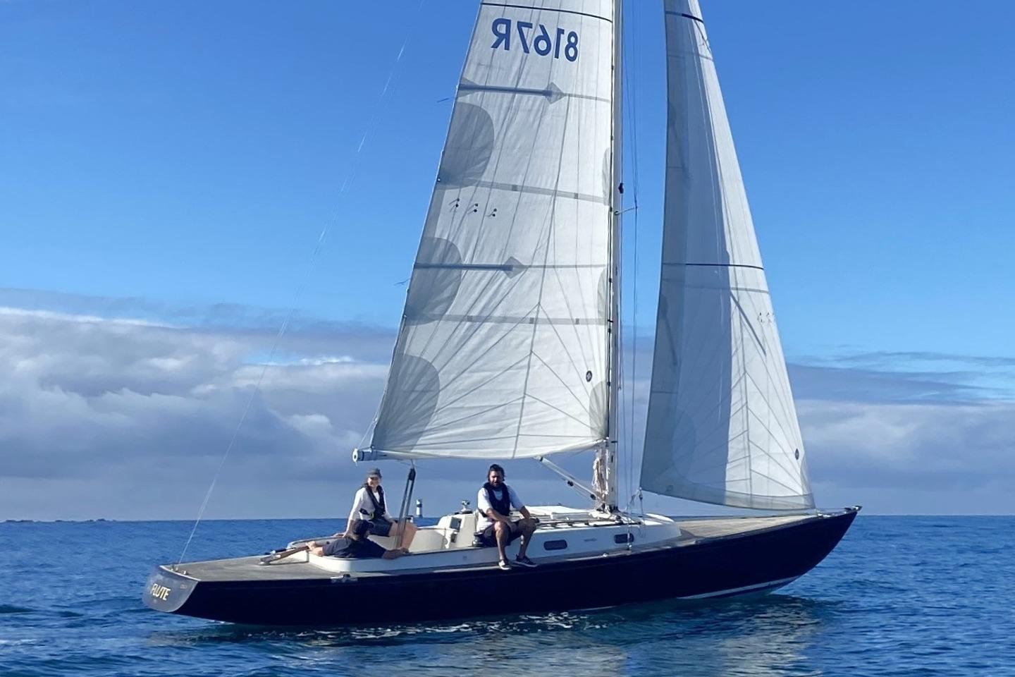 Sailing on a 2013 Rustler 33 yacht in calm blue waters under a clear sky.