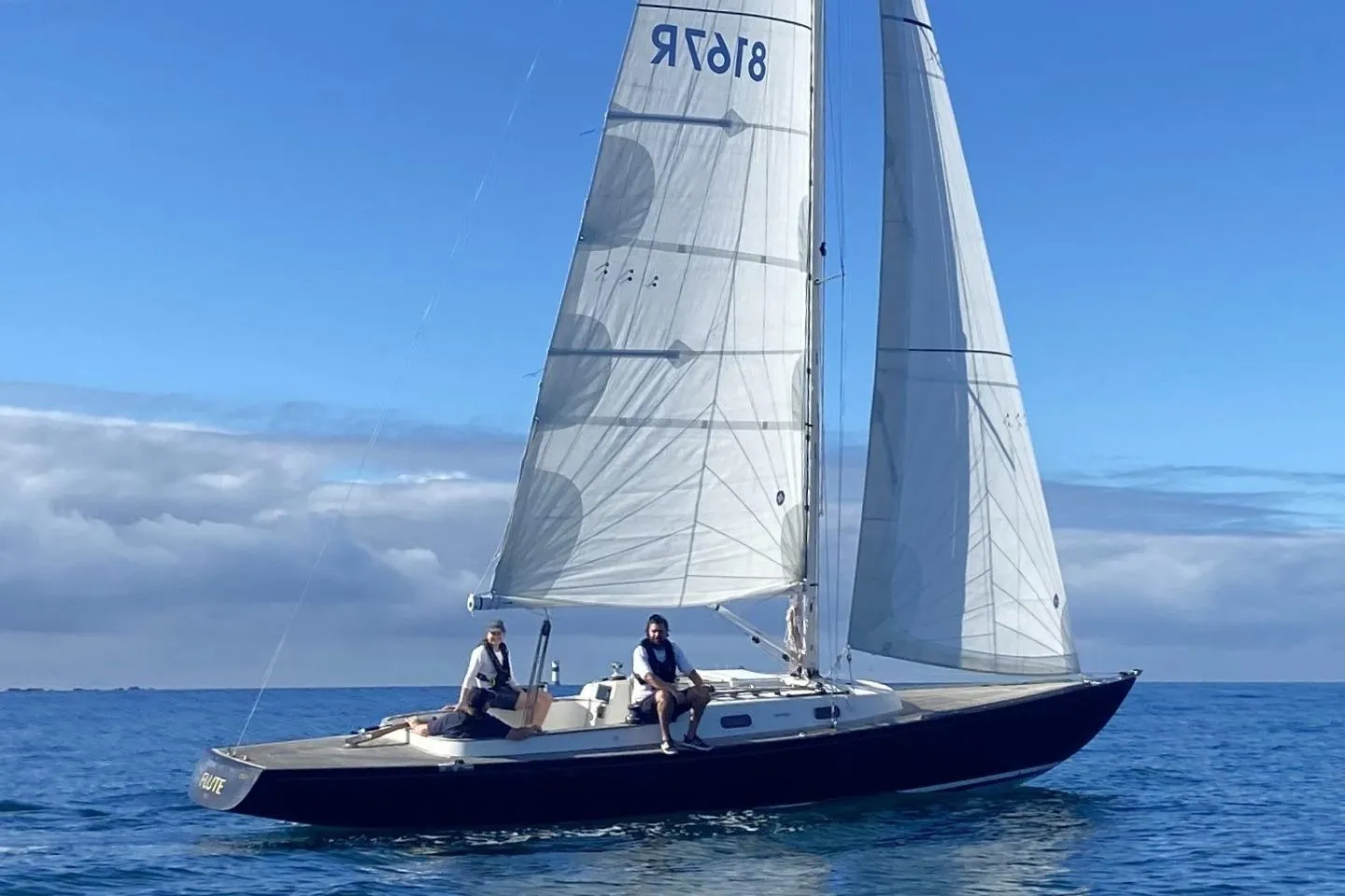 Sailing on a 2013 Rustler 33 yacht in calm blue waters under a clear sky.