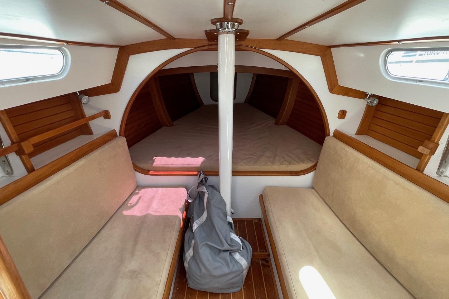 Cozy interior of 2013 Rustler 33 sailboat with wooden accents and seating.