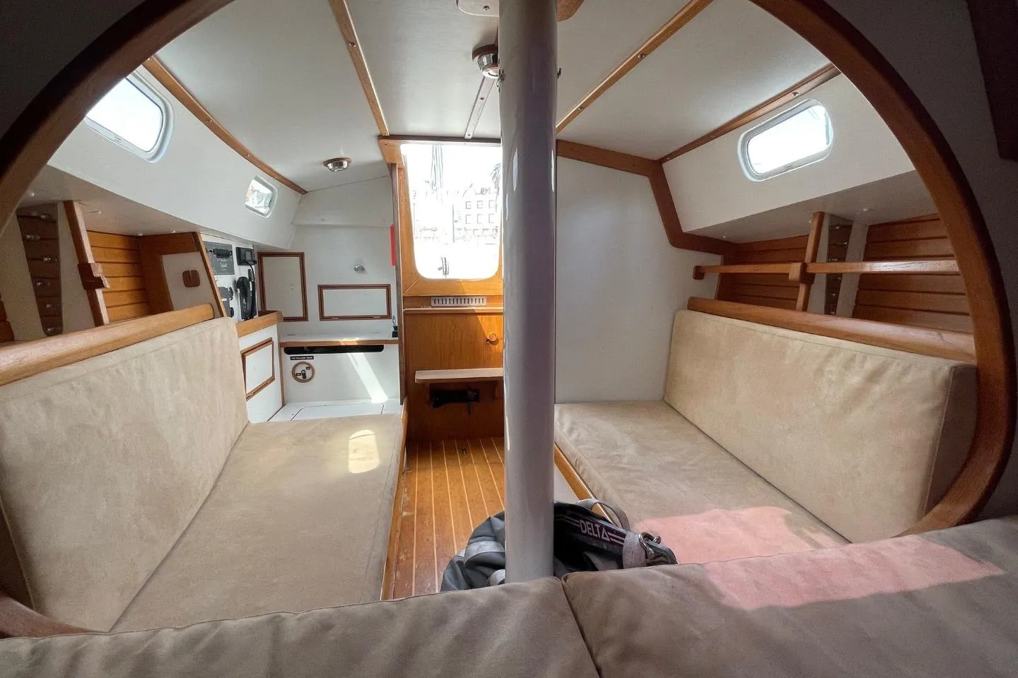 Interior of a 2013 Rustler 33 sailboat, featuring cozy seating and wooden accents.