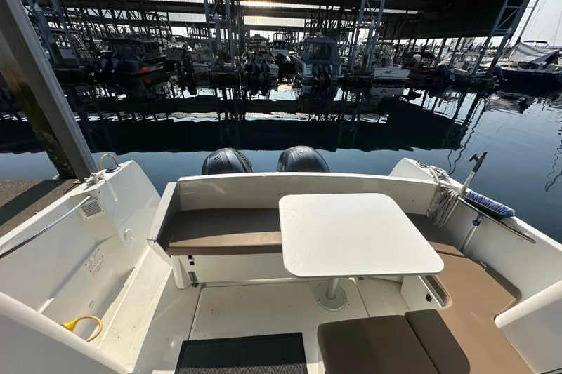 Makai Yacht Photos Pics 2016 Jeanneau Merry Fisher 855 boat interior with seating and table at marina.