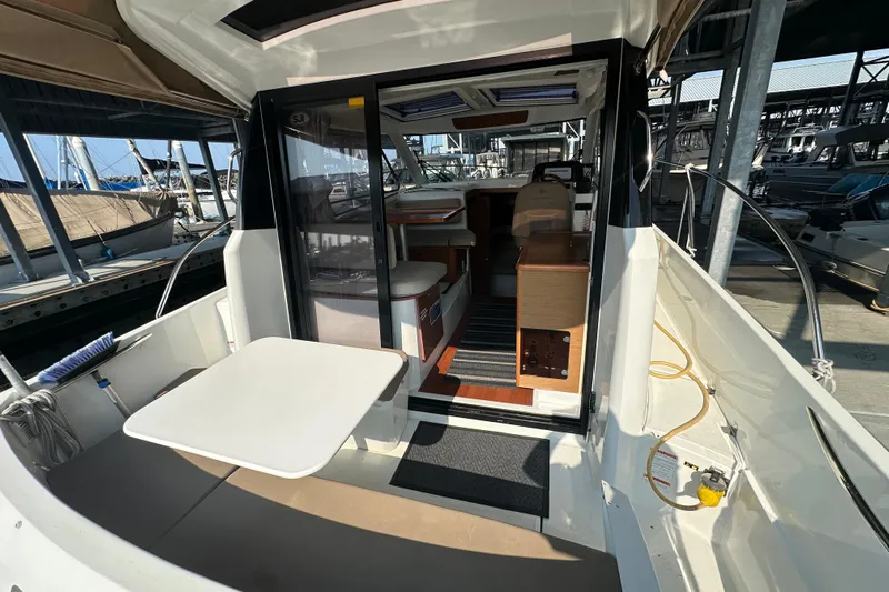 Makai Yacht Photos Pics 2016 Jeanneau Merry Fisher 855 boat interior with table and seating area.