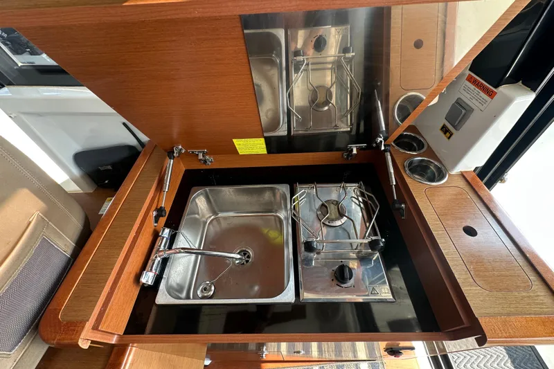 Makai Yacht Photos Pics Compact kitchen area in 2016 Jeanneau Merry Fisher 855 with sink and stove.