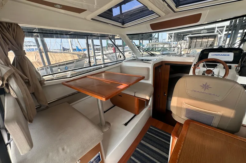 Makai Yacht Photos Pics Interior of 2016 Jeanneau Merry Fisher 855 boat with seating and navigation area.