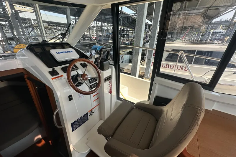 Makai Yacht Photos Pics Interior helm of 2016 Jeanneau Merry Fisher 855 with steering wheel and navigation equipment.