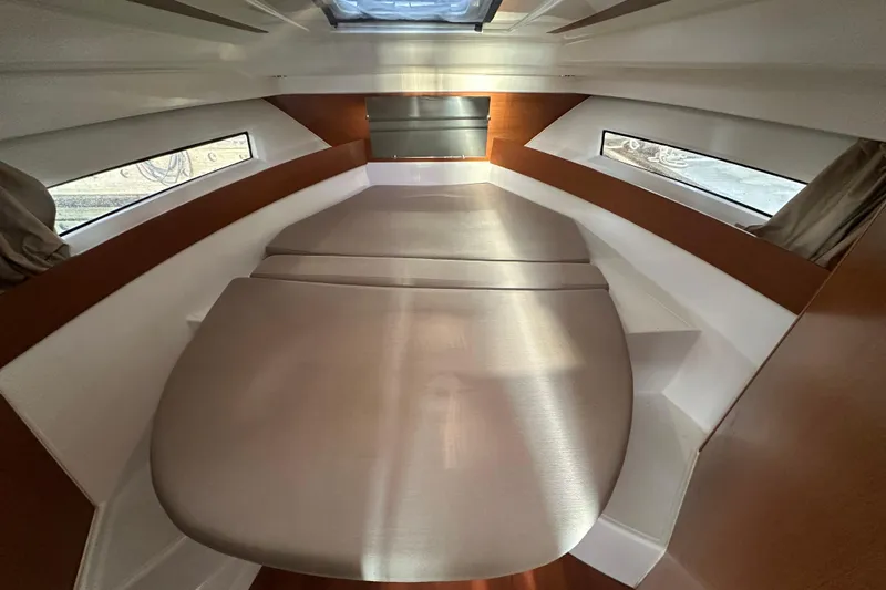 Makai Yacht Photos Pics 2016 Jeanneau Merry Fisher 855 cabin interior with cozy bed and side windows.