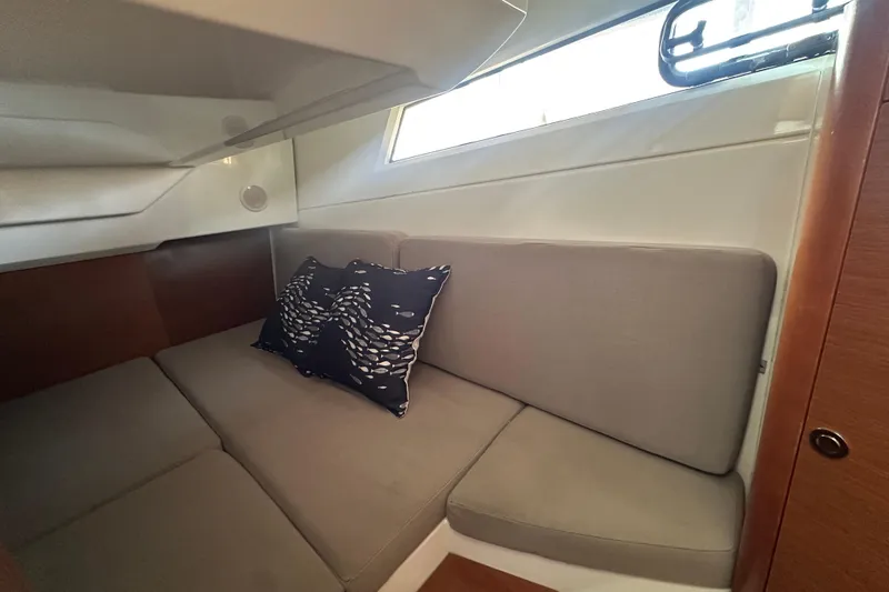 Makai Yacht Photos Pics Cozy cabin interior of 2016 Jeanneau Merry Fisher 855 with cushions and window.