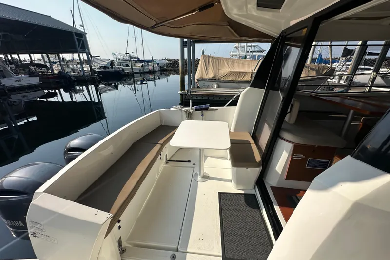 Makai Yacht Photos Pics 2016 Jeanneau Merry Fisher 855 boat interior with seating and table at marina.