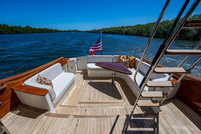 Vera North Yacht Photos Pics Hinckley Talaria 55 Flybridge MKII 2021 yacht deck with seating, table, and American flag.