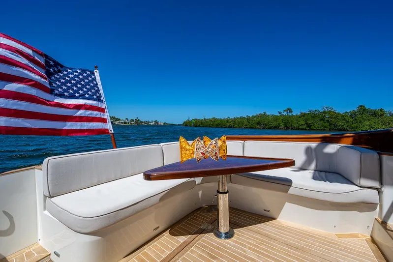 Vera North Yacht Photos Pics Hinckley Talaria 55 Flybridge MKII 2021 yacht deck with seating, table, and American flag.