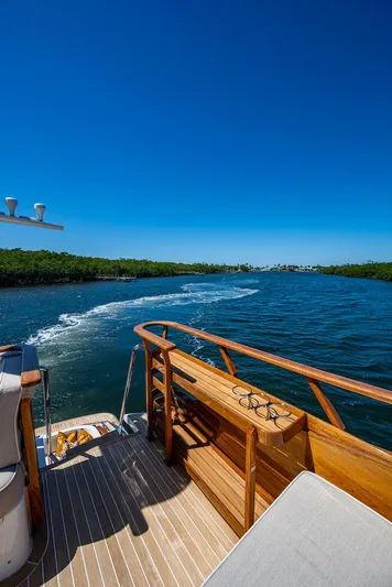 Vera North Yacht Photos Pics Hinckley Talaria 55 Flybridge MKII 2021 cruising on a sunny day, showcasing elegant wooden deck.