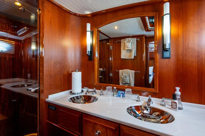 Vera North Yacht Photos Pics Luxurious bathroom in 2021 Hinckley Talaria 55 Flybridge MKII yacht with dual sinks and wood finish.