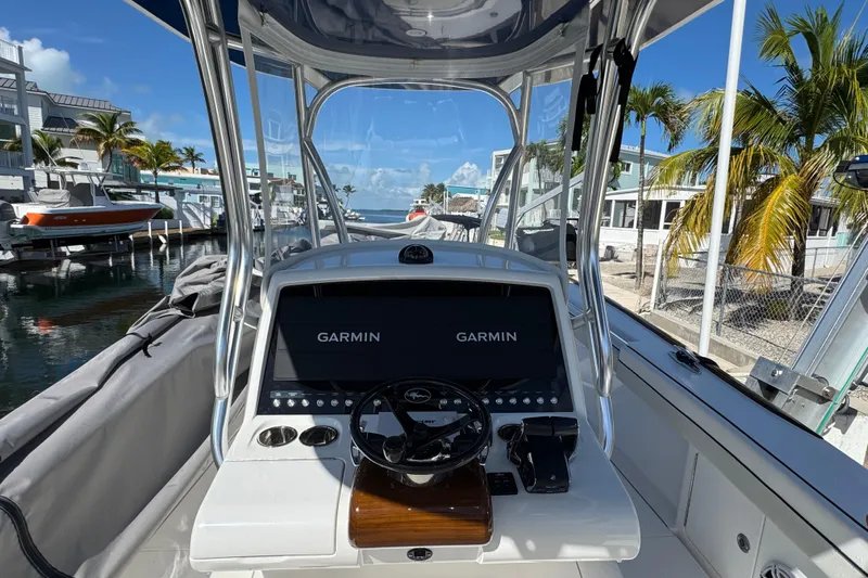  Yacht Photos Pics 2024 Valhalla V-29 Hybrid boat cockpit with Garmin displays, docked near palm trees.
