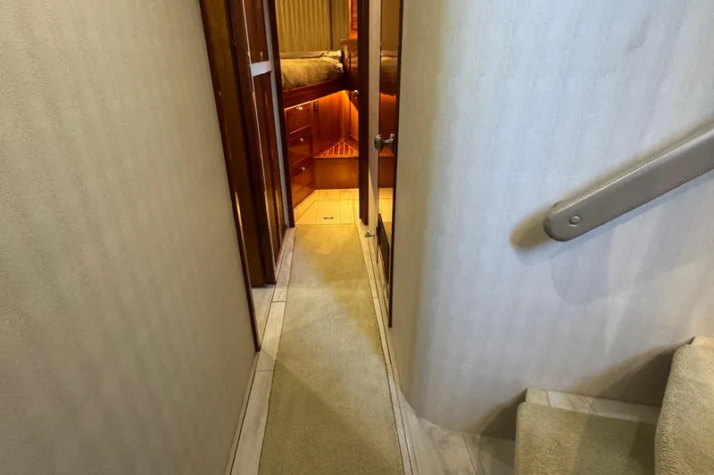 Baby Girl Yacht Photos Pics Hallway inside 1999 McKinna 57 Pilothouse yacht, featuring wooden doors and carpeted flooring.