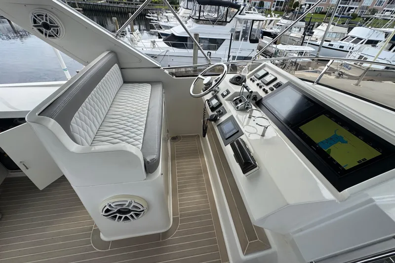 Baby Girl Yacht Photos Pics 1999 McKinna 57 Pilothouse helm with modern navigation equipment and cushioned seating.