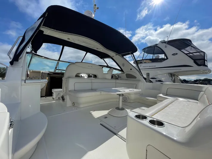 Limin Yacht Photos Pics 2000 Sea Ray 460 Sundancer yacht interior with seating and table under a sunny sky.